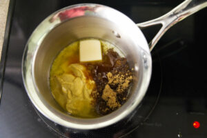 Ingredients for a glaze in a sauce pan on the stove.