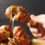 Cheese oozing out of Traeger stuffed chicken leg after taking a bite.