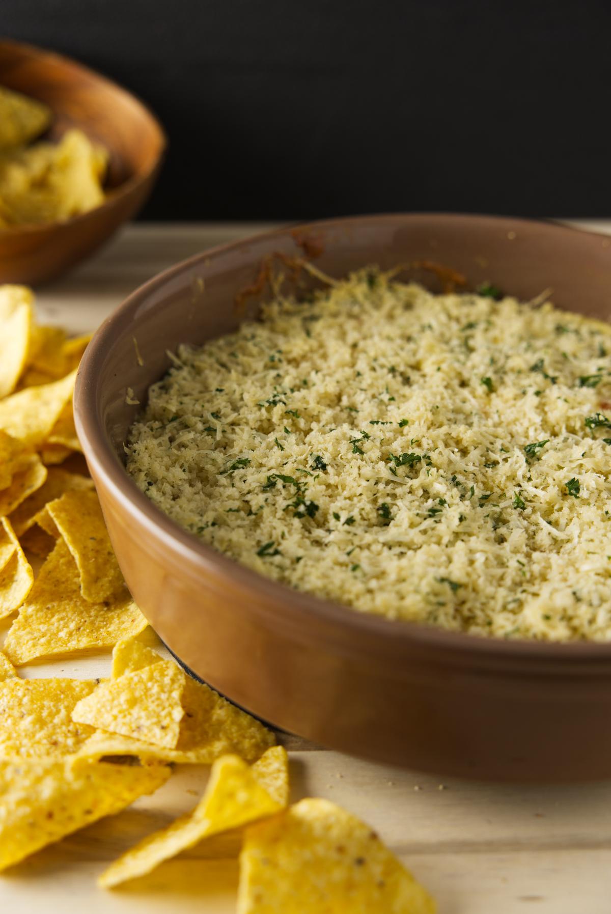 Large bowl of smoked queso surrounded by tortilla chips.