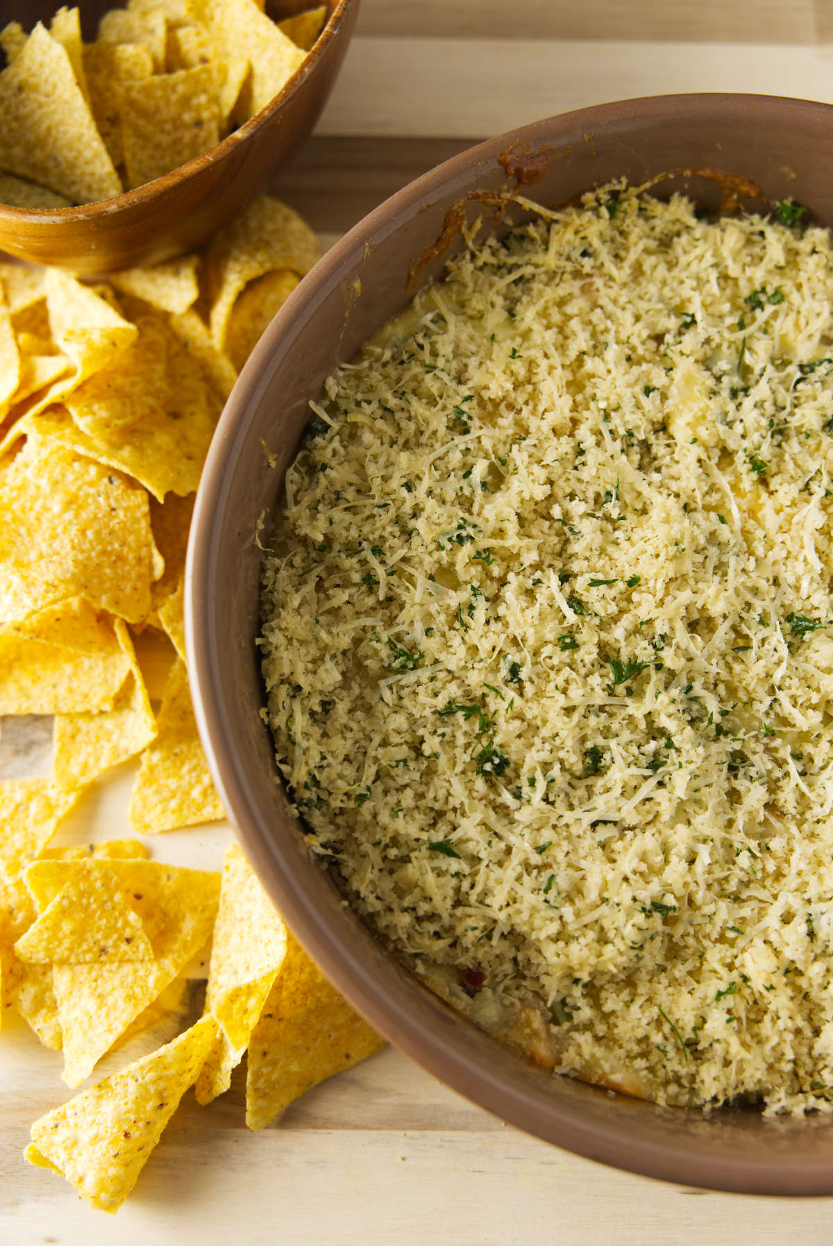 Overhead shot of a large bowl of smoked jalapeño popper dip with a bread crumb topping.