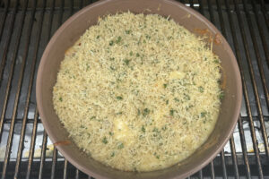 Smoked queso dip in bowl on the smoker grates.
