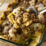 Scooping French toast casserole from baking dish.