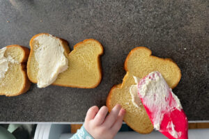 Spreading cream cheese on bread.