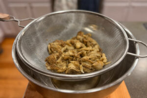 Roasted eggplant flesh in a strainer to drain excess moisture.