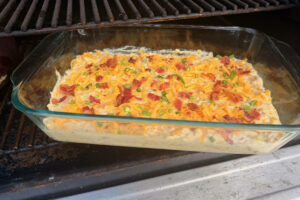 Corn casserole in baking dish on the smoker grates.