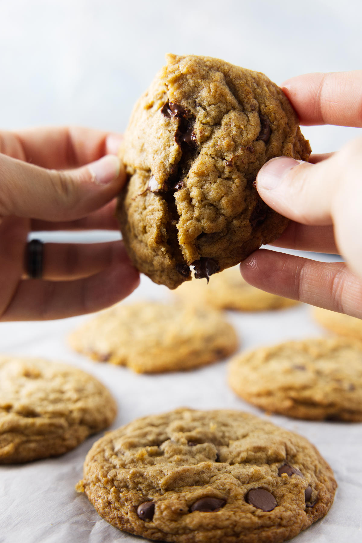Breaking apart a banana bread chocolate chip cookie with a gooey center.