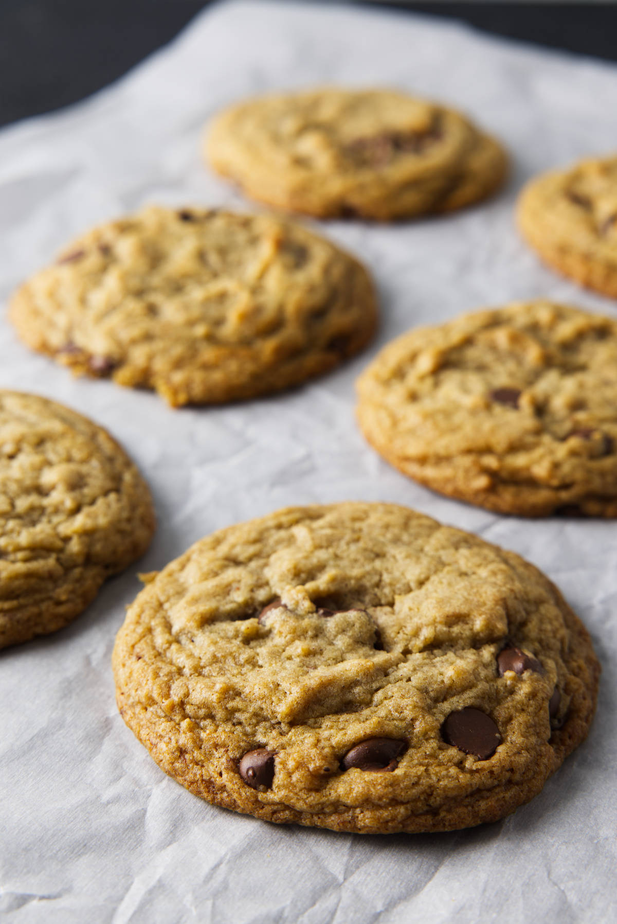 Freshly baked banana bread cookies on parchment paper.
