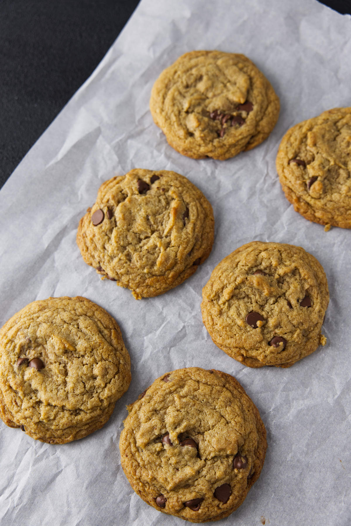 Several chocolate chip banana bread cookies on parchment paper.
