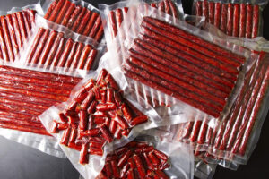 Jalapeño cheddar venison snack sticks in vacuum sealed bags.