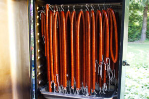 Venison snack sticks hanging in smoker.