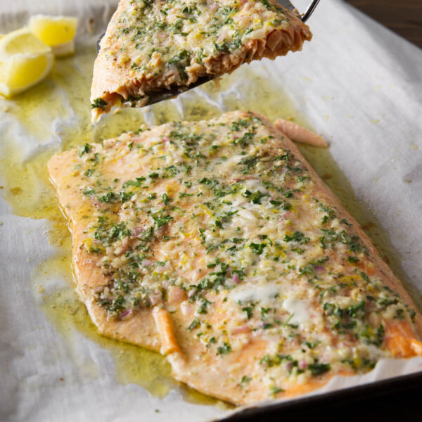 Slicing and serving a piece of pellet grill salmon using a fish turner.