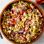 A closeup of Italian pasta salad with smoked vegetables and salami.
