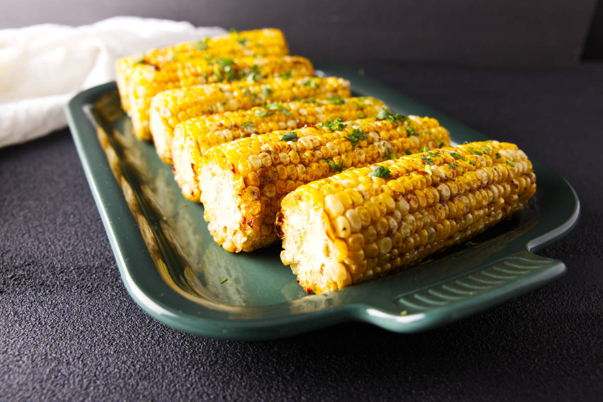 Close-up of pellet grill smoked corn on the cob with smoky barbecue butter.