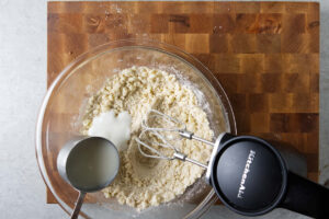 Adding buttermilk to the cobbler batter.