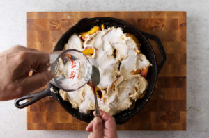 Pouring hot water over the cobbler topping.