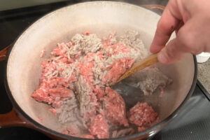 Browning ground sausage in a large dutch oven.